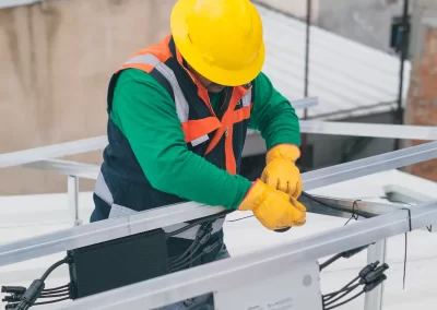 "Electrician from Ace Projects connecting wires to a rooftop frame for solar panel installation in East London, Eastern Cape